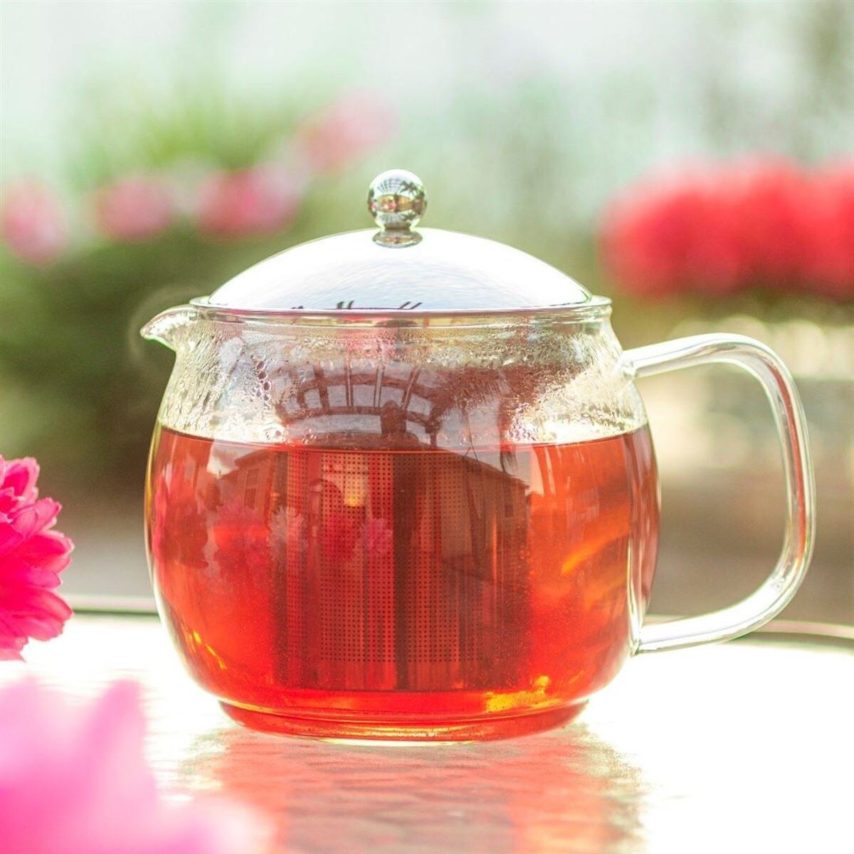 Glass infuser teapot brewing tea.